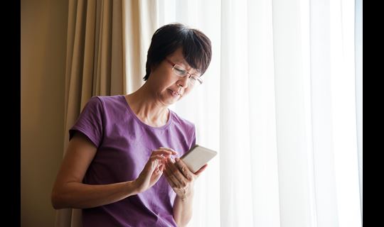 asian woman on smartphone at home