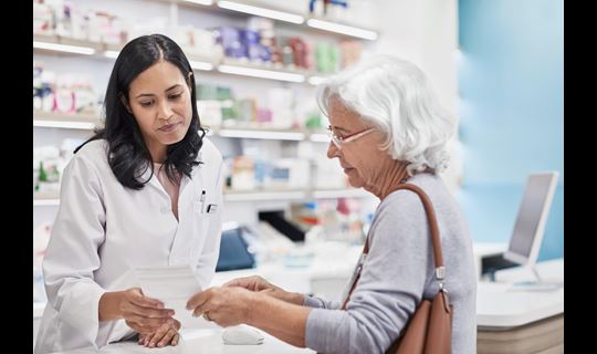 female pharmacist with elderly female patient