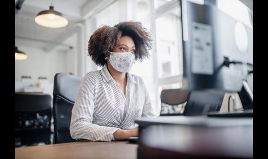 woman with mask at computer