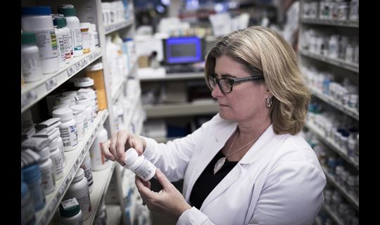 Pharmacist stocking bottles