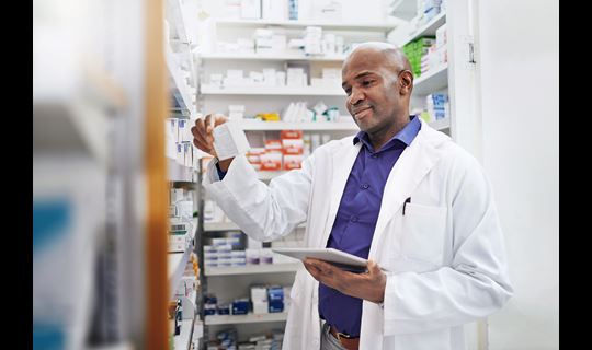 Cropped shot of a pharmacist using a digital tablet in a chemist
