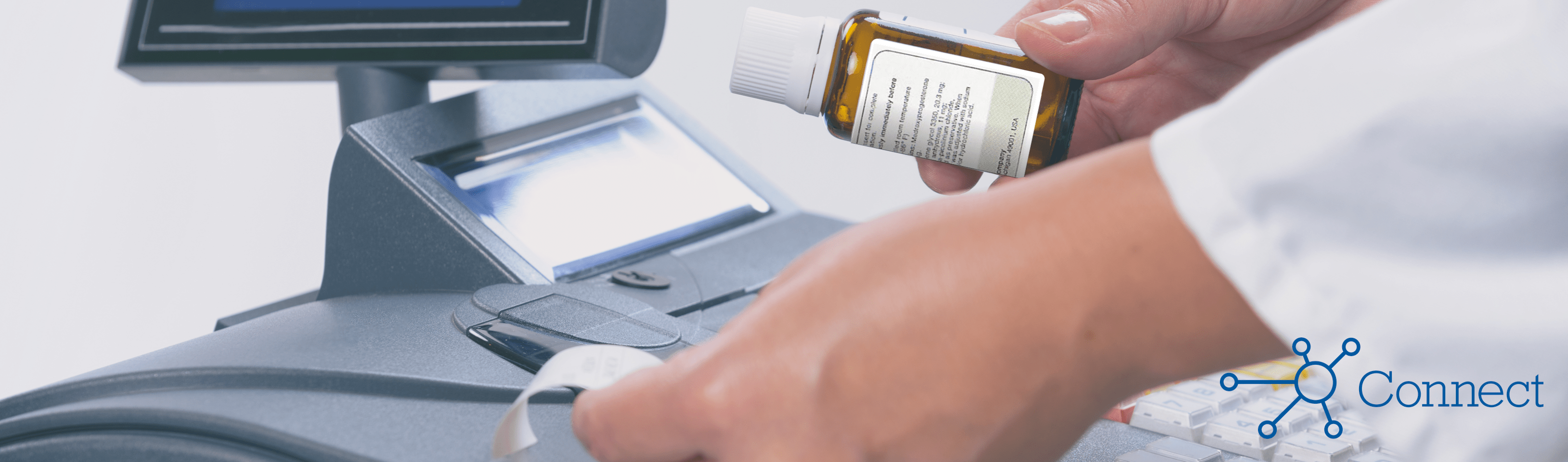 A pharmacist ringing up a prescription at a cash register